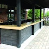 This precast outdoor bar countertop by Fishstone Studio was designed in five pieces to accommodate the shape and existing support poles.