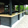 This precast outdoor bar countertop by Fishstone Studio was designed in five pieces to accommodate the shape and existing support poles.