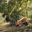 The CASE TV620B tackles a mulching task on soft ground in a heavily wooded area.