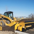 The accessory extends to the left or right of the FH-R and dispenses material over the curb to backfill with dirt or aggregate.