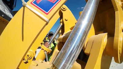 Technicians inspect the hydraulics used in the excavator. This year’s high equipment prices push more contractors to consider buying used equipment.