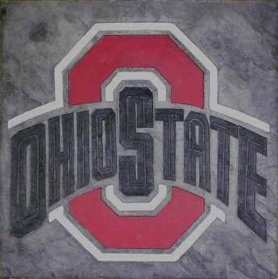 A custom stamped logo showcases how decorative concrete can seamlessly blend branding and design.