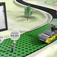 Dynapac roller compactor on green terrain with thermal imaging data displayed on tablet showing 94.3% density and 250°F temperature reading