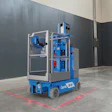 Blue Genie scissor lift with red safety markings on concrete floor in industrial warehouse