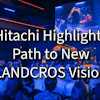 Hitachi industrial event presentation featuring robotic arm demonstration and audience in blue-lit venue with 'Watch FCP' branding