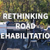 Road rehabilitation equipment with asphalt paving machinery in forest setting, promoting rethinking road rehabilitation