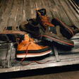 Orange and black work boots with safety gear arranged in a truck bed