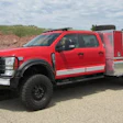 Red and silver fire truck with emergency equipment parked on rural road