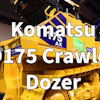 Yellow and blue Komatsu D175 Crawler Dozer on display at an indoor equipment showroom with 'WATCH FCP' badge overlay