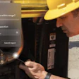 Construction worker in hard hat and safety vest inspecting hydraulic equipment during site inspection