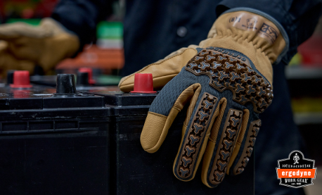 Close-up of tan and black tactical work gloves with textured grip pattern worn during hands-on task